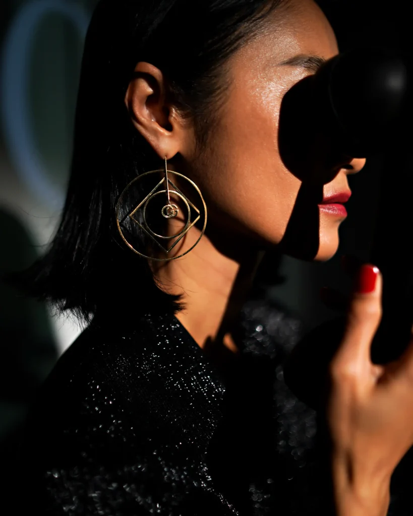creative studio photography of an gucci earring. dark colours with an elements of a portrait.