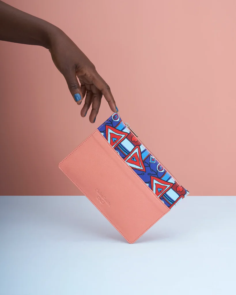 creative still life photography of a wallet with a hand holding it. dynamic print and peach colours