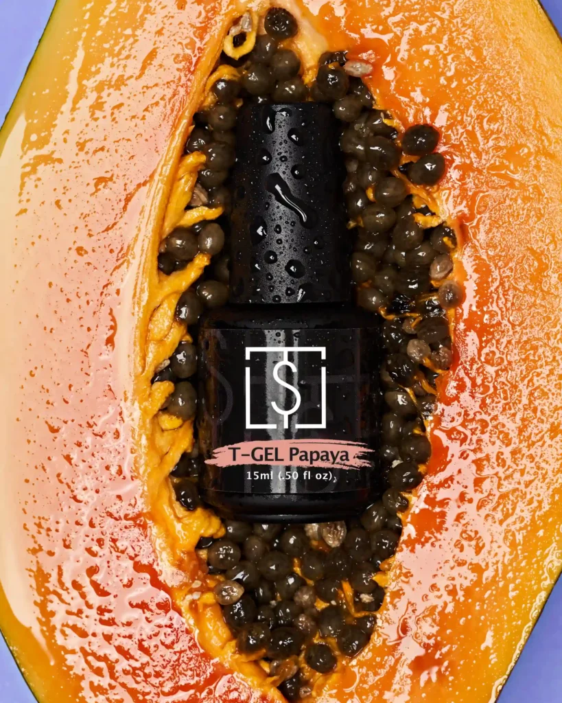 creative still life close up photography of nail biab bottle on the papaya fruit with water drops on it.