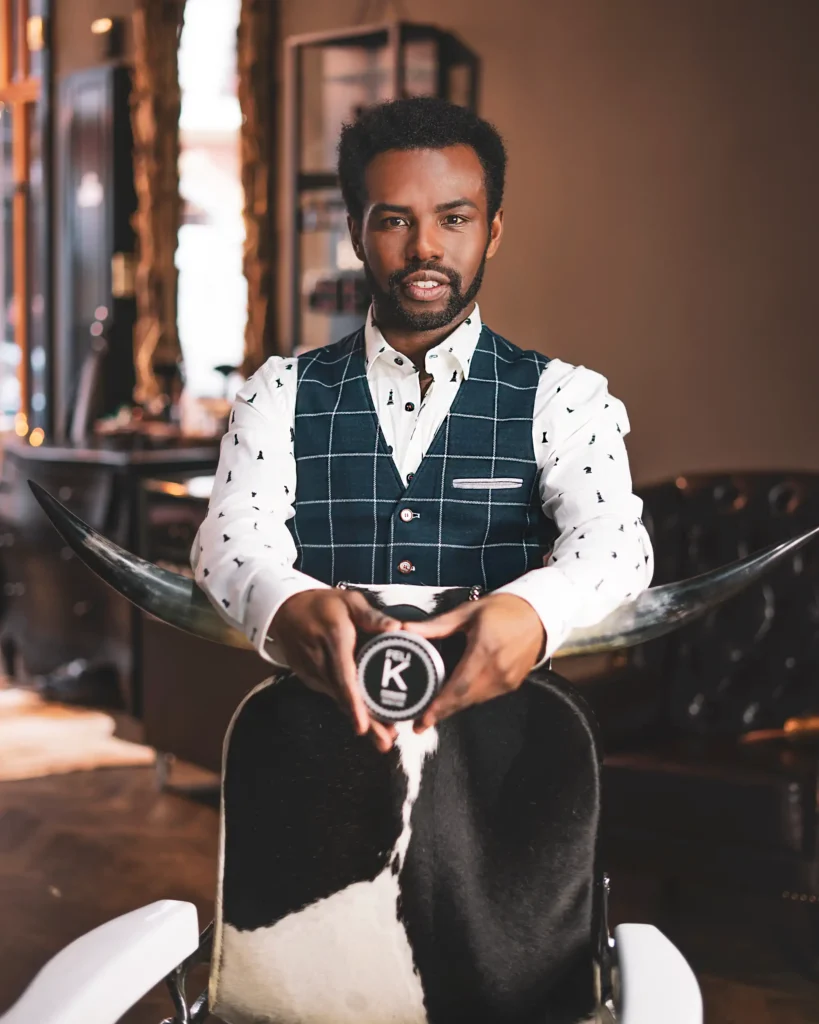 personal branding photography of a hairdresser standing in the barbershop with a brand merchandise and hair product