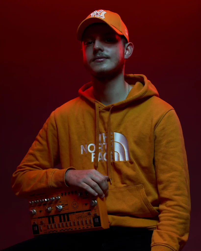 studio fotografie of a man in a red lights and yellow hoodie