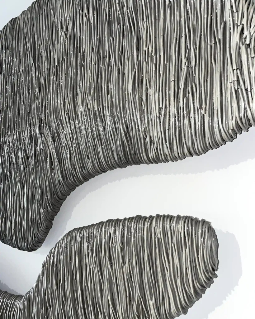 painting sculpture on the wall in the interior, thin lines of the grey and silver plaster art