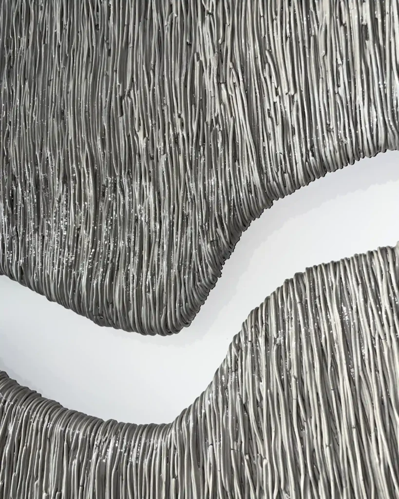 painting sculpture on the wall, thin lines of the grey and silver plaster