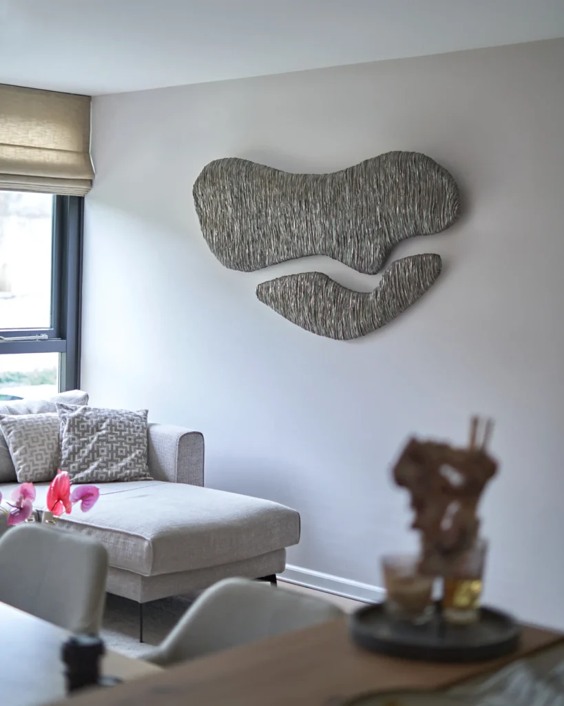 painting sculpture on the wall in the interior, thin lines of the grey and silver plaster art