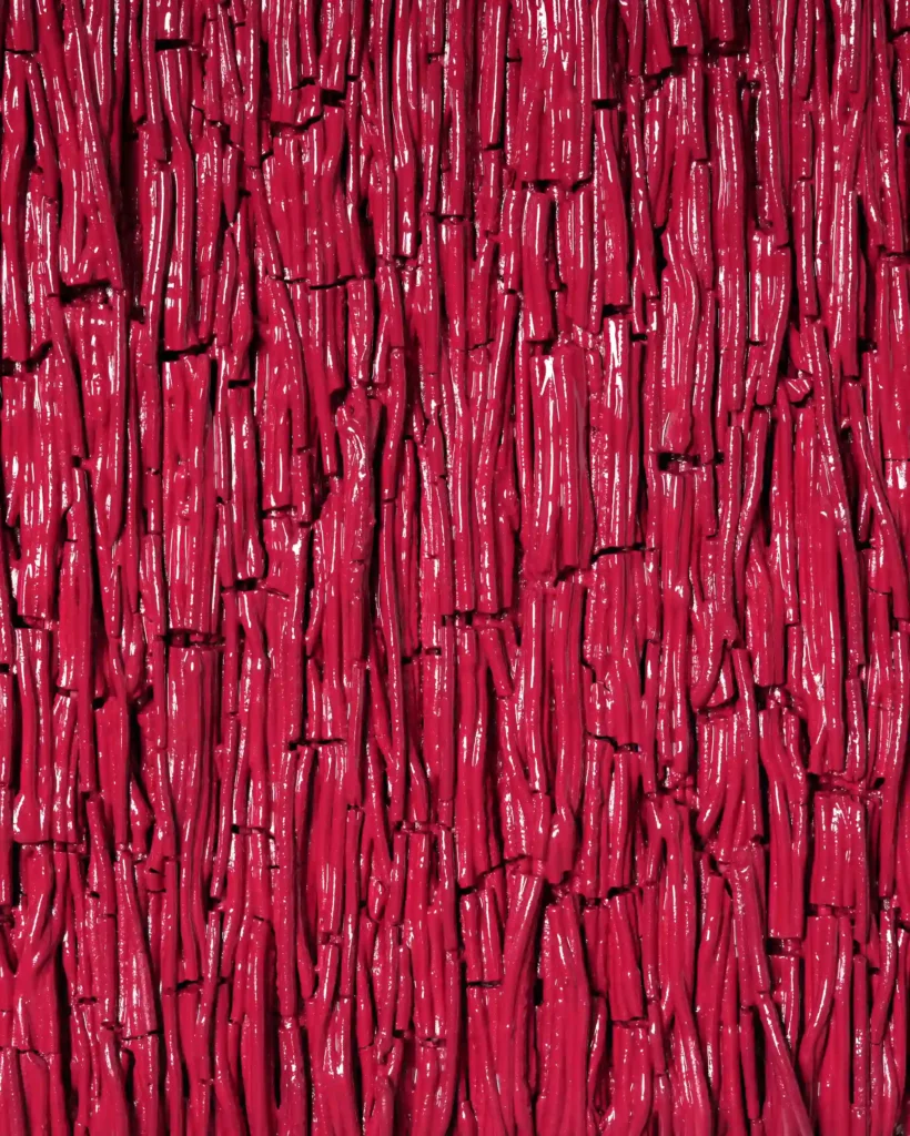 painting sculpture on the wall, thin lines of the red and pink plaster art. Close up of the detail